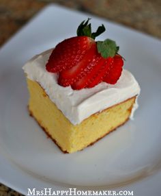 a piece of cake with white frosting and strawberries on top