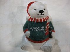 a glass polar bear ornament with a coca - cola shirt on