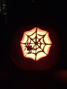 a carved pumpkin with a spider web on it