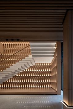 the interior of an office building with stairs and walls made of wooden slatted panels