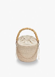 Our Ling bag is handwoven from high-quality straw and features a sturdy bamboo handle. A drawstring closure keeps your belongings secure and a gold chain adds visual interest. Handcrafted from all-natural straw. Features a drawstring lining and top handles. Measures 6.25”H by 6" Dia. with a 4.5” handle drop. Elegant Natural Bucket Bag With Bamboo Handle, Natural Pouch Bucket Bag For Vacation, Eco-friendly Top Handle Bucket Bag With Bamboo, Eco-friendly Bucket Bag With Bamboo Handle, Elegant Vacation Bucket Bag With Bamboo Handle, Woven Bucket Bag With Top Handle In Natural Fiber, Woven Bucket Bag With Top Handle, Trendy Woven Jute Bucket Bag, Eco-friendly Woven Bucket Bag With Top Handle