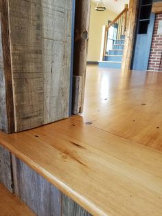 an empty room with wooden floors and stairs