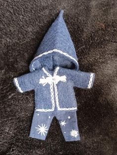 a baby's blue and white snowsuit laying on top of a black carpet