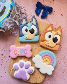 some decorated cookies on a wooden board with confetti and sprinkles