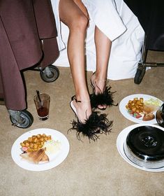 a woman's feet in black feathers on plates