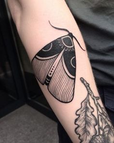 a black and white butterfly tattoo on the arm