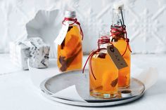 two glass bottles filled with liquid sitting on top of a metal tray