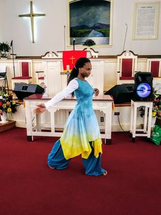 a woman in a blue and yellow dress is standing in the middle of a church