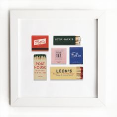 a white frame with matches and matchsticks on it in front of a white wall