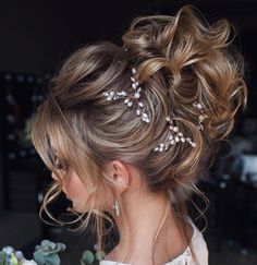 a woman with her hair in a messy updo and some pearls on it's head