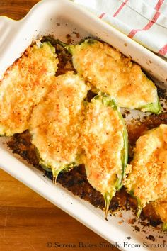 a casserole dish with zucchini and cheese in it on a wooden table