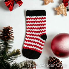 a pair of red and white striped socks next to christmas decorations on a white surface