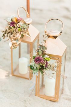 two gold lanterns with flowers and candles