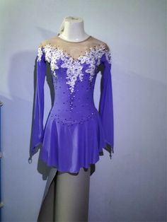 a purple and white figure skating dress on display