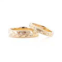 two gold wedding bands with diamonds on them