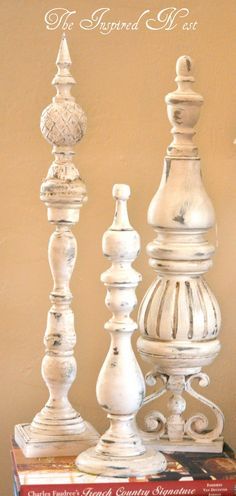 three white chess pieces sitting on top of each other in front of a bookshelf