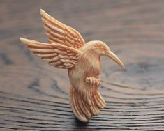 a figurine of a bird on a wooden surface