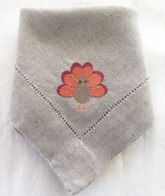 a gray handkerchief with a turkey embroidered on it