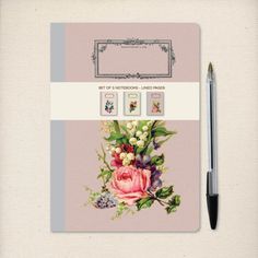 a notepad with flowers on it next to a pen