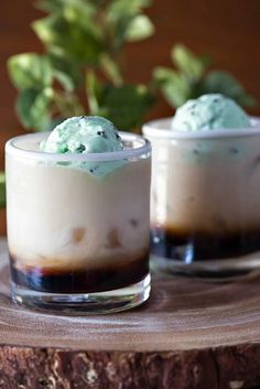 two glasses filled with ice cream on top of a wooden table