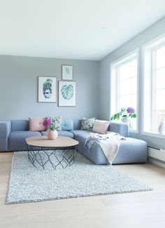 a living room with blue couches and pictures on the wall above it's coffee table