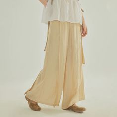 Inspired by Song Ku 宋裤 (Song Dynasty trousers), these wide legged pants are perfect for daily wear. Made of light and breezy fabric, these pants are lined within to ensure no flashes. Features the traditional waist tie but paired with a modern zipper closure. Triangular side pleats, creating the iconic flared shape. Wear as-is or under skirts! These fun pants can easily be styled with modern and traditional pieces. This item has a 7 day construction period. Materials: 82.6% viscose, 17.4% nylon Solid Color Wide Leg Parachute Pants For Spring, Beige Wide-leg Harem Pants, Beige Baggy Wide-leg Harem Pants, Non-stretch Beige Ankle-length Wide Leg Pants, Beige Non-stretch Ankle-length Pants, Baggy Ankle-length Wide Leg Pants For Spring, Beige Ankle-length Pants With Pockets, Non-stretch Beige Wide-leg Harem Pants, Baggy Full-length Beige Harem Pants