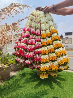 a person holding a large flower arrangement in their hand