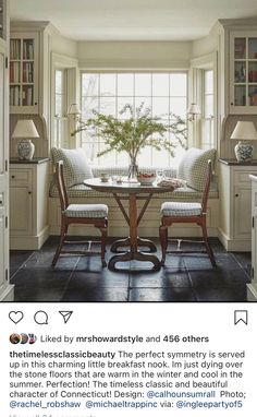 the dining room table is surrounded by two chairs and a vase with a plant in it