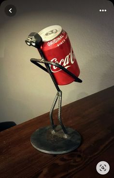 a lamp made to look like a coca cola can with a stick sticking out of it