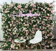 two white chairs sitting in front of a wall covered with pink and white flowers that says angelflowers