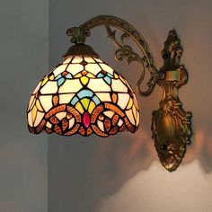 a wall light with a stained glass shade on it's arm and back end