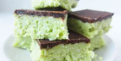 four pieces of green cake sitting on top of a white plate