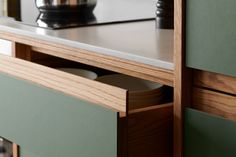 an open drawer in a kitchen cabinet next to a counter