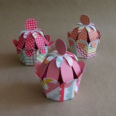 three colorful paper crowns sitting on top of a table next to each other and one is folded in the shape of a crown