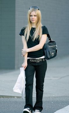 a woman walking down the street with a handbag