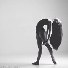 a black and white photo of a woman bending over