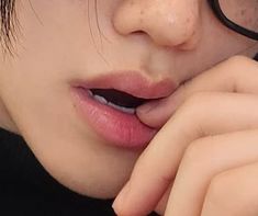 a close up of a person wearing glasses with their hand on her chin and looking at the camera