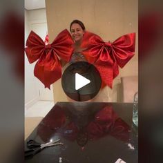 a woman standing in front of a table with red bows on it