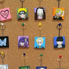 a bunch of key chains that are hanging on a bulletin board with anime characters painted on them