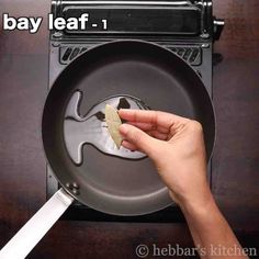 someone is holding a piece of bread in front of a frying pan with the word bay leaf on it