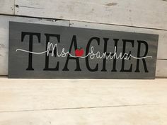 a wooden sign that says teacher with an apple on it