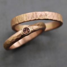 two gold wedding bands with a brown diamond