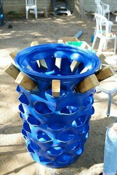 a large blue vase sitting on top of a sandy ground