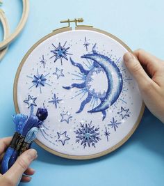 someone is working on an embroidery project with blue and white stars in the sky,