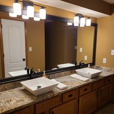 a bathroom with two sinks and large mirrors