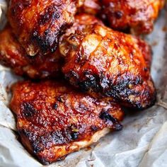 chicken wings covered in bbq sauce sitting on wax paper