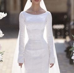 a woman in a white wedding dress and veil