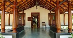 the inside of a building with wooden pillars and columns on either side of the entrance