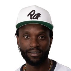 a man with a beard wearing a white hat and beaded necklace on his neck