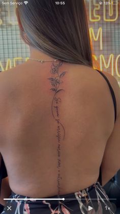 the back of a woman's neck with a tattoo on her left shoulder and an inscription above it